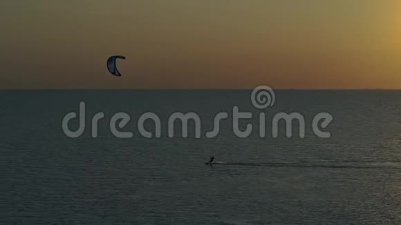 日落时分一个人在海里风筝冲浪从高处射击视频的预览图