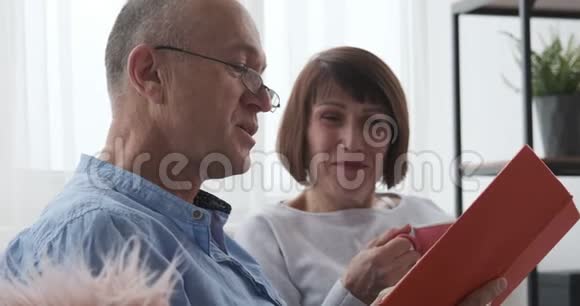 年长夫妇在家一起读一本书视频的预览图