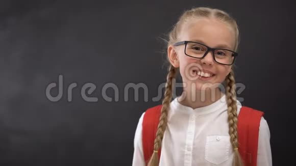 戴眼镜的聪明女学生在镜头前微笑渴望知识教育视频的预览图