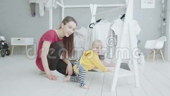 女婴在室内学着站着不需要帮助视频的预览图
