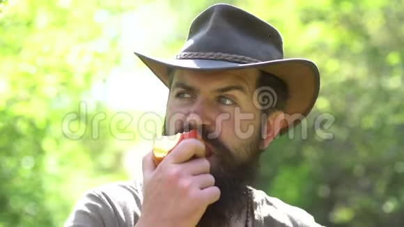 长胡子的农民用铲子特写农夫在农场里玩和吃苹果的肖像乡村生活希普斯特视频的预览图