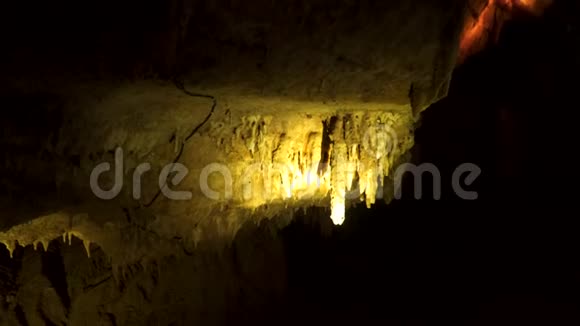昏暗的洞穴和钟乳石挂在洞穴天花板上视频的预览图