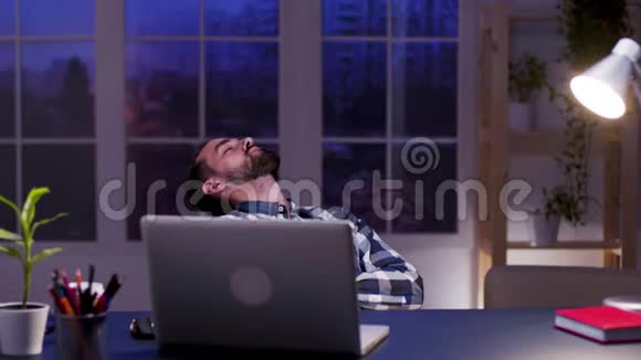 疲倦的商人睡在他家办公室的椅子上视频的预览图