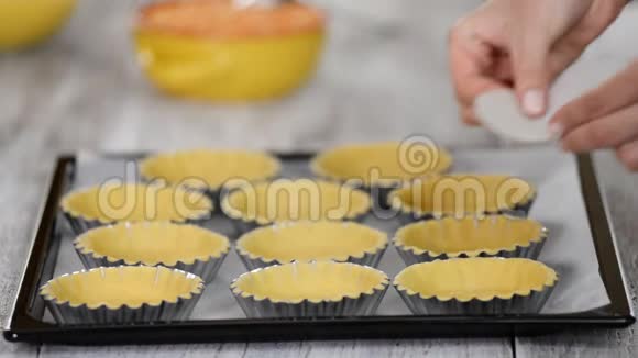 糕点厨师做馅饼每个蛋挞上盖一层小片羊皮纸并装满干豌豆视频的预览图