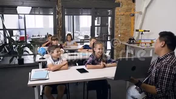 高中教师在信息技术课上为学生讲解和展示笔记本电脑视频的预览图