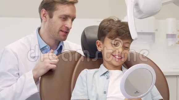 成熟的男牙科医生和迷人的小男孩一起工作视频的预览图