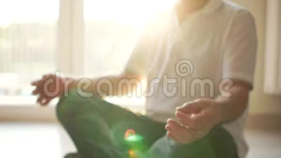 冥想和瑜伽修行一位年长的瑜伽士坐在地板上的莲花位置阳光照射视频的预览图