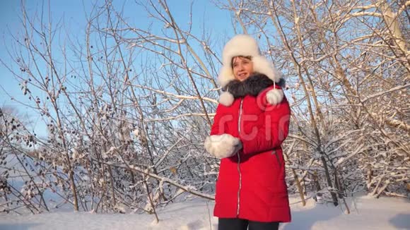 美丽的少女在冬季公园玩耍幸福的女孩在森林日落时用手举起雪白雪皑皑视频的预览图