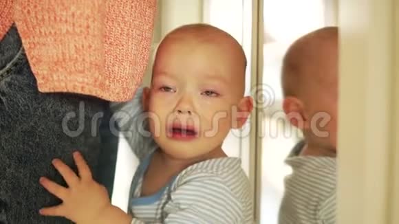 一个半岁的婴儿站在母亲身边哭泣孩子要钢笔惹怒了孩子母亲和婴儿视频的预览图