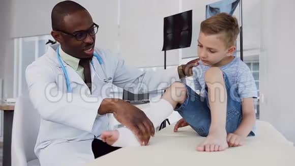 男医生检查小男孩腿上的绷带视频的预览图