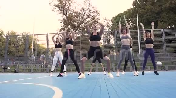 在绿色公园的运动场上漂亮的年轻女性在健身运动中缓慢运动视频的预览图
