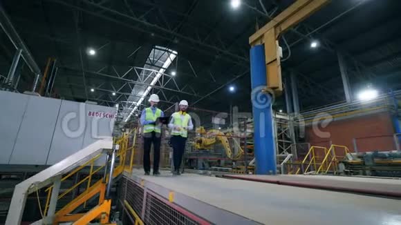 男同事工业专家正沿着现代化工厂设施行走视频的预览图
