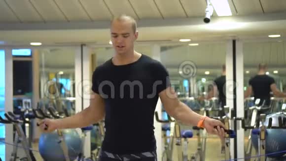 年轻的运动员在健身房里用跳绳训练慢动作视频的预览图