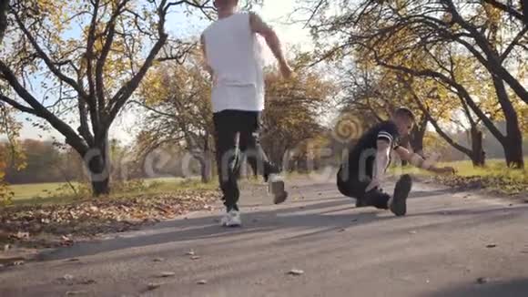 两个年轻的白人强壮的运动员在秋季公园伸展成年帅哥在运动前热身视频的预览图