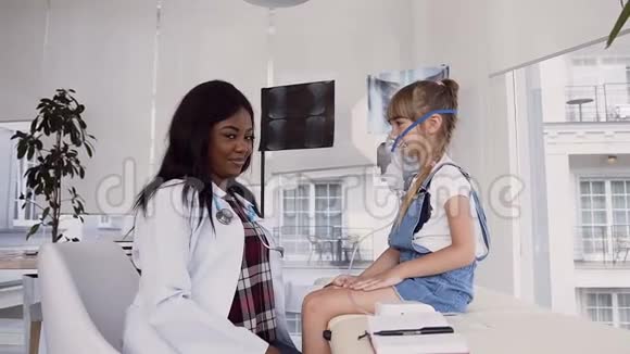 小女孩在医院里用吸入面罩而女医生则在镜头上显示一切正常视频的预览图
