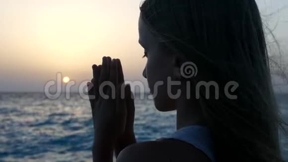 日落海滩上的儿童祈祷体贴的祈祷孩子海边的攻击性女孩视频的预览图