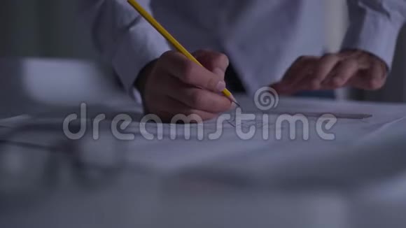 用铅笔特写男性手在蓝图上写笔记从事新项目的成年白种人建筑师视频的预览图