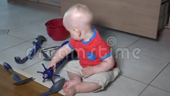 白人男孩玩厨房用具坐在瓷砖地板上可爱的幼儿视频的预览图
