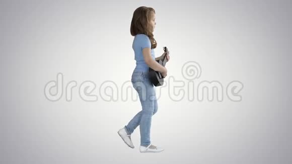 一个小女孩在渐变背景下双手拿着四弦琴走路视频的预览图