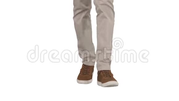男人穿着米色牛仔裤和白色背景的棕色运动鞋走路视频的预览图