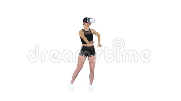 快乐微笑的年轻女孩使用VR耳机眼镜玩舞蹈游戏第一次在白色背景视频的预览图