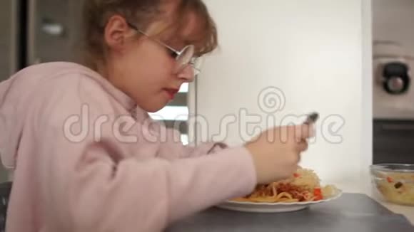 在学校食堂里吃意大利面条的少女健康饮食的女孩戴眼镜视频的预览图