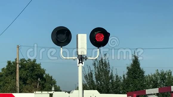 在一个铁路交叉路口用一个降低的屏障关闭红色交通灯视频的预览图