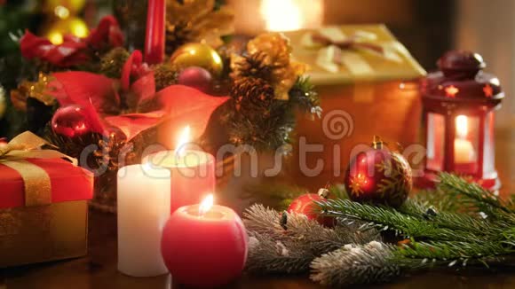 特写4k视频在木桌上燃烧蜡烛对抗圣诞装饰品并在壁炉中燃烧火焰完美完美完美视频的预览图