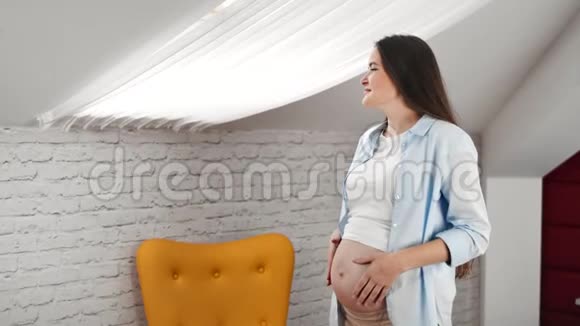家中怀孕的年轻女性梦想着看着窗外享受周末视频的预览图