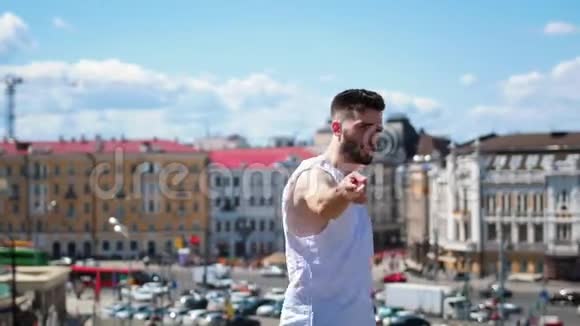 年轻迷人的男子纹身自由式舞蹈在市中心的顶端指向相机视频的预览图