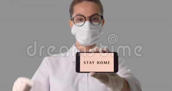 戴着医用口罩的女人在手机上显示了她的签名上面写着呆在家里视频的预览图
