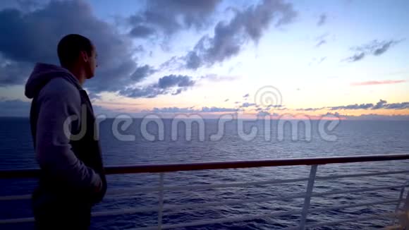 肖像青年转向地平线望着海面上的黎明视频的预览图