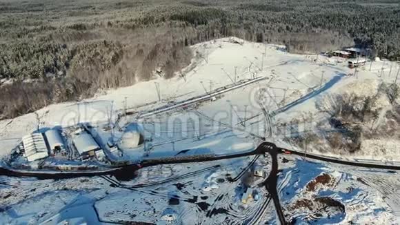 冬季大型滑雪场的空中观景台道路被森林包围的山坡以蓝色衬托视频的预览图