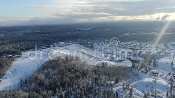 大滑雪场山坡和滑雪场的空中景观冬季森林环绕蓝天多云视频的预览图