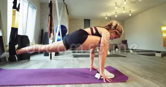 在一家有氧运动工作室一位女士用带子练习伸展运动以帮助腿部更用力更有力地伸展视频的预览图