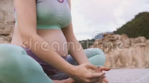特写孕肚女人做瑜伽坐莲呼吸练习视频的预览图