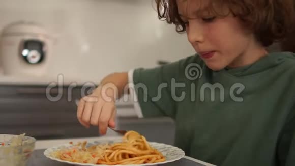 近距离肖像迷你少年在家吃午饭男生吃意大利面条健康饮食青少年视频的预览图