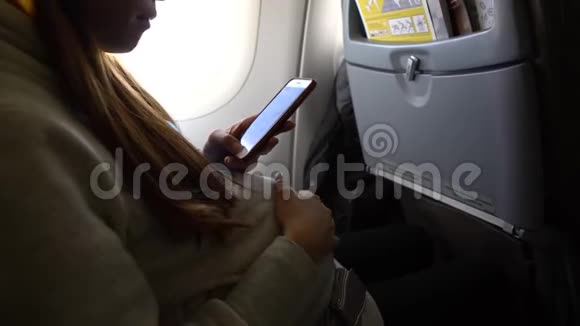 4K亚洲孕妇拿着智能手机在飞机上摸肚子视频的预览图