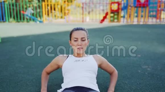 运动女性在新鲜空气中对腹肌进行锻炼那个女孩在街上参加体育活动视频的预览图