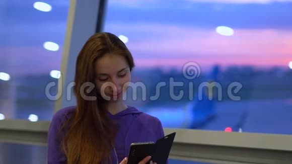 在日落时分年轻女孩在机场慢动作地打电话视频的预览图