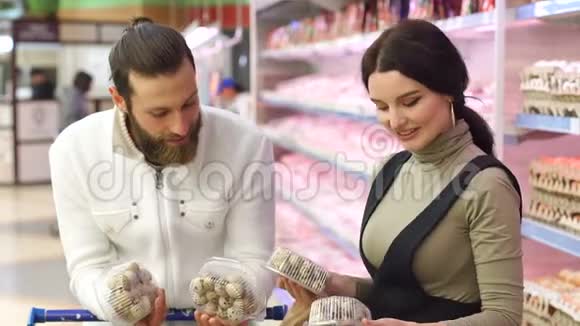 年轻的幸福夫妇在超市里选择鹌鹑蛋慢动作肖像视频的预览图