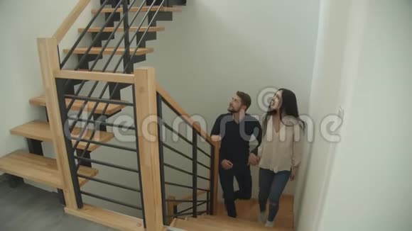 千禧白种人夫妇爬上楼梯双手环视着一栋新买的房子兴奋不已视频的预览图