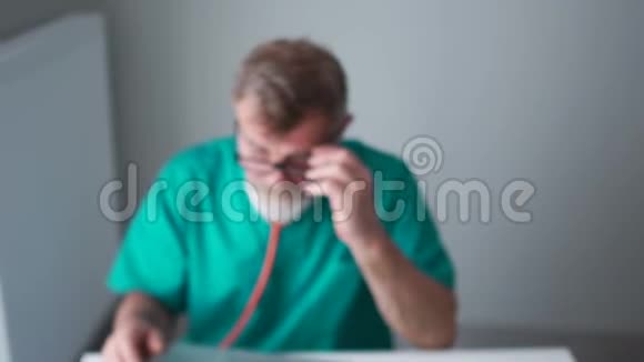 治疗师的亲密画像一位年长的医生一位身穿绿色医用长袍的教授为一位病人提供医疗服务视频的预览图