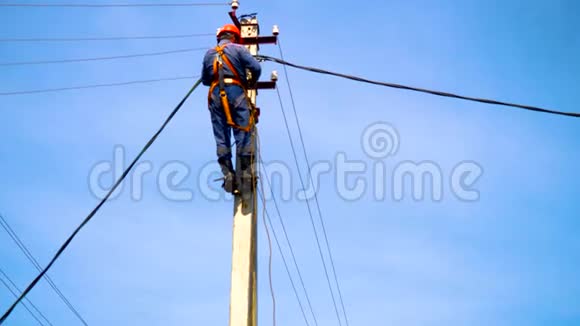 一名电工在新安装的电线杆上工作连接一条新的电力线视频的预览图