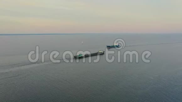 两艘货船一艘货船和一艘油轮在海湾内相互航行俯视空中视频的预览图