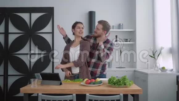 一对爱笑的情侣在美食中的画像快乐的女孩和男人一起准备健康的食物和新鲜的蔬菜视频的预览图