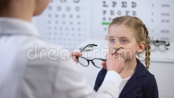 女医生给不满的女孩戴上眼镜孩子感到不安全心烦意乱视频的预览图