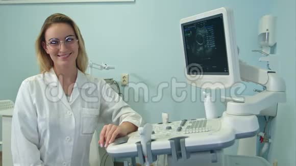 戴眼镜的女医生微笑着在超声室看着摄像机视频的预览图