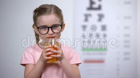 积极的小女孩喝胡萝卜冰沙健康的营养眼睛维生素视频的预览图