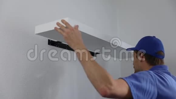 杂工在白墙上安装架子视频的预览图